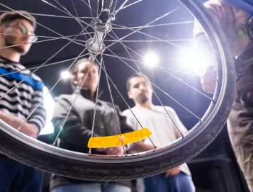 Trois jeunes inscrits au programme Phoenix de l’organisme Déclic participent à un atelier de réparation de vélos.